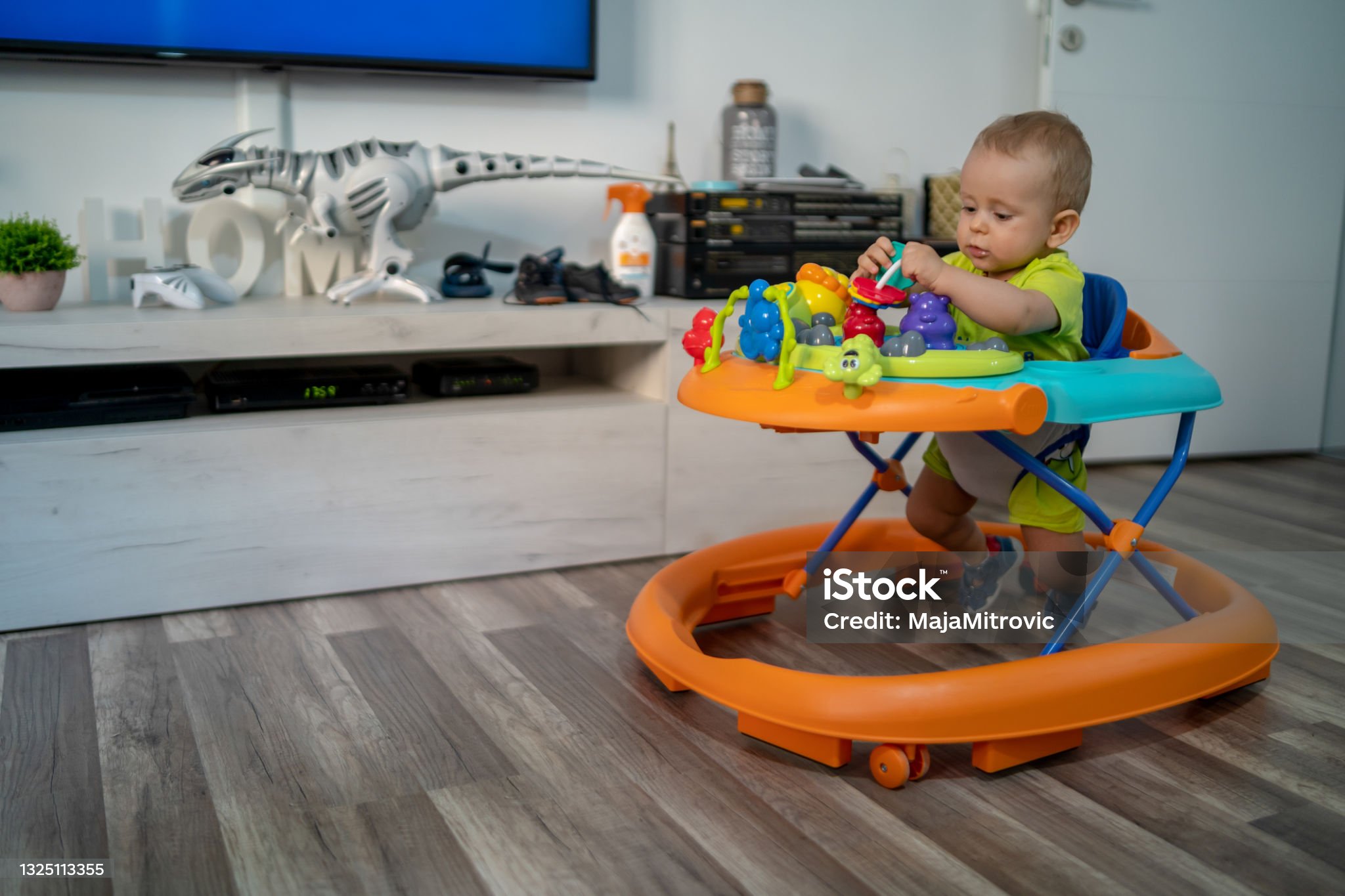 First steps of the boy in a baby walker